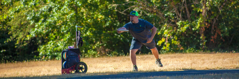 En disc golfer der gør klar til at putte foran sin ZÛCA vogn